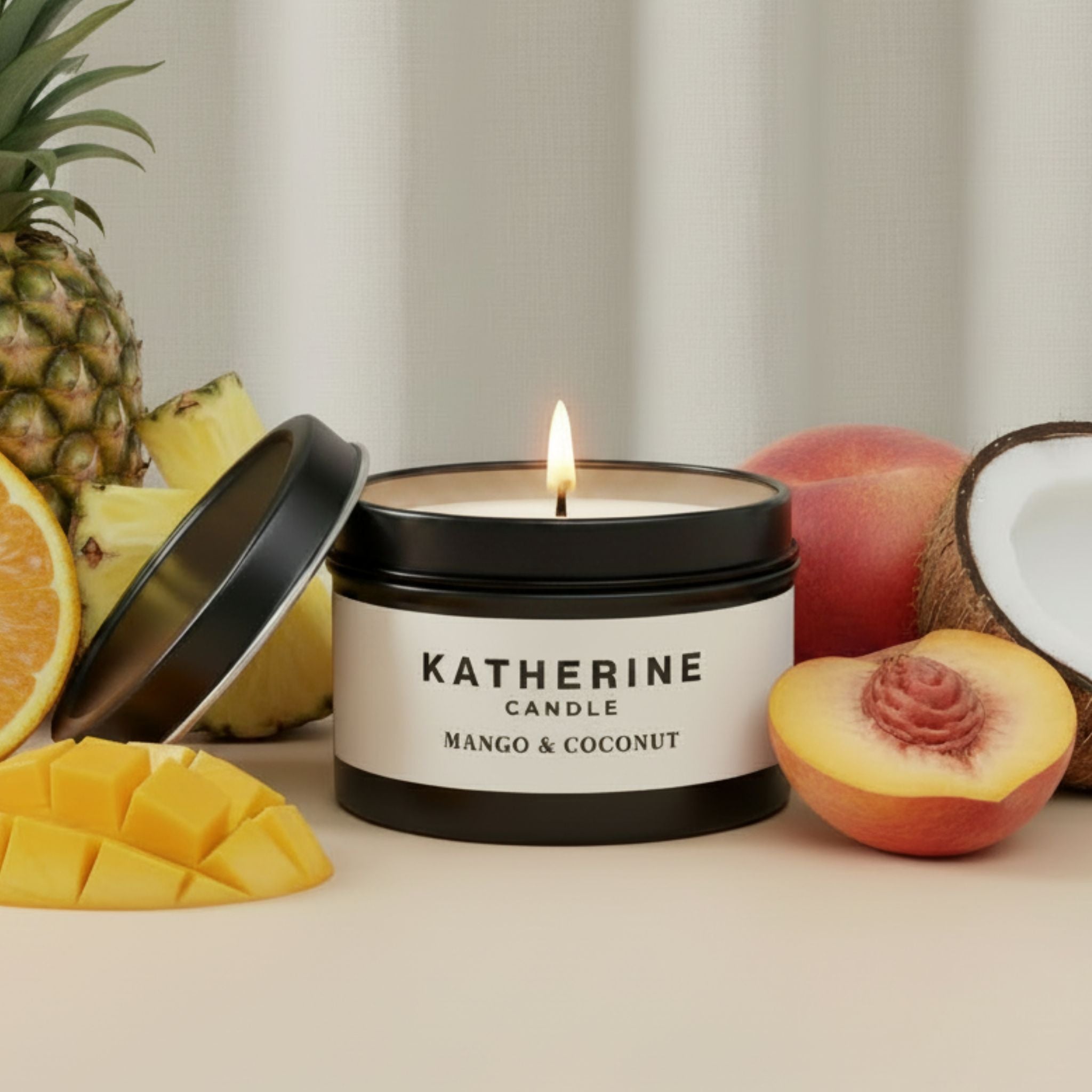 Scented candle jar with matte black lid and KATHERINE label; lit wick, mango & coconut.