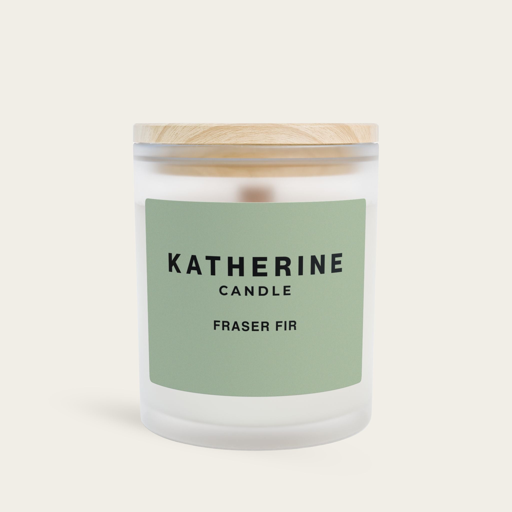Fraser fir scented candle in clear glass jar with green label and white wax