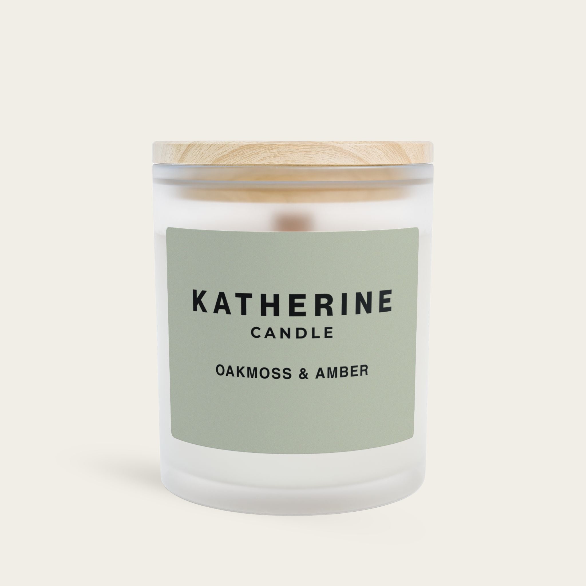 Candle jar in frosted glass with wood lid; green label reading KATHERINE CANDLE