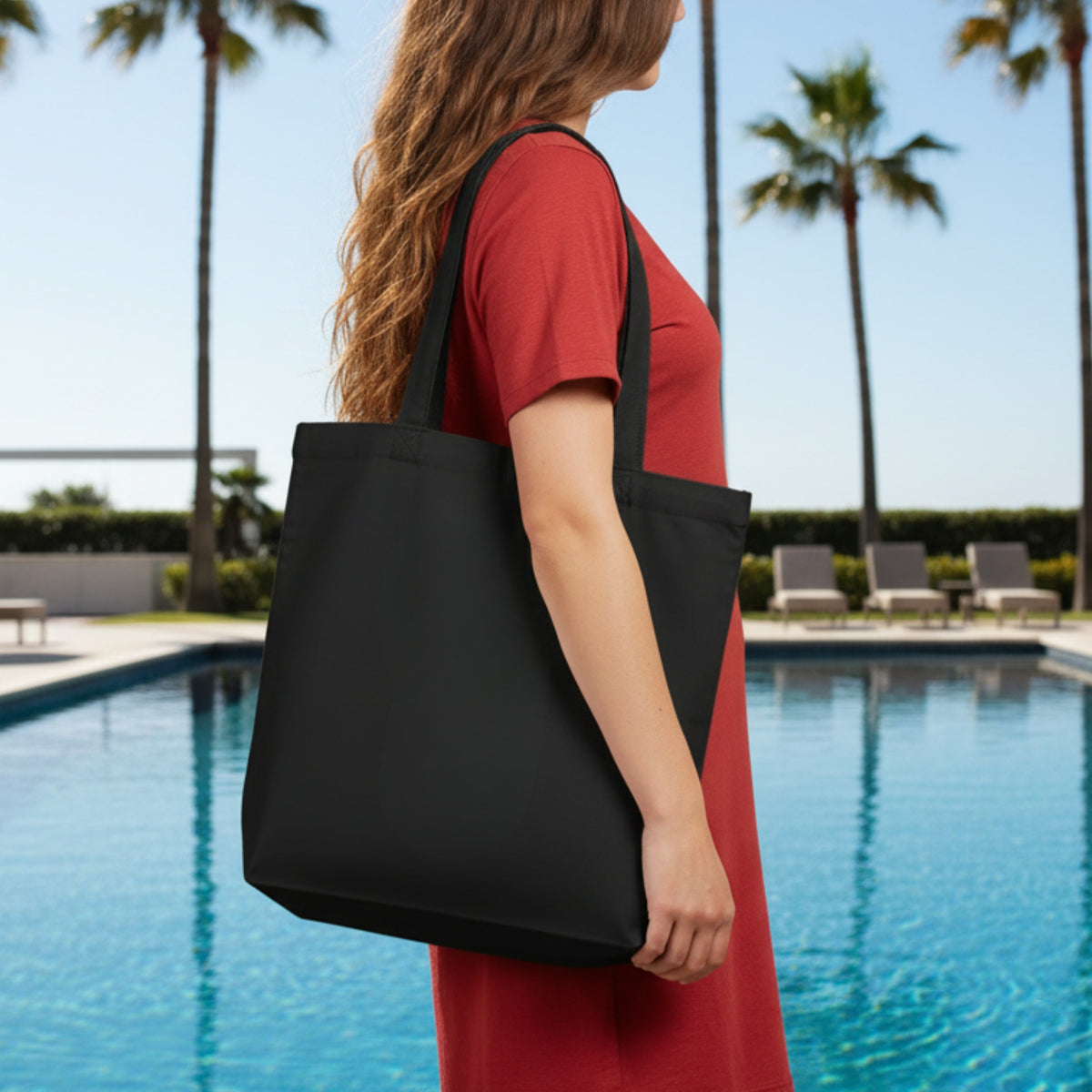 Black canvas tote bag carried by model, open top with wide handles.