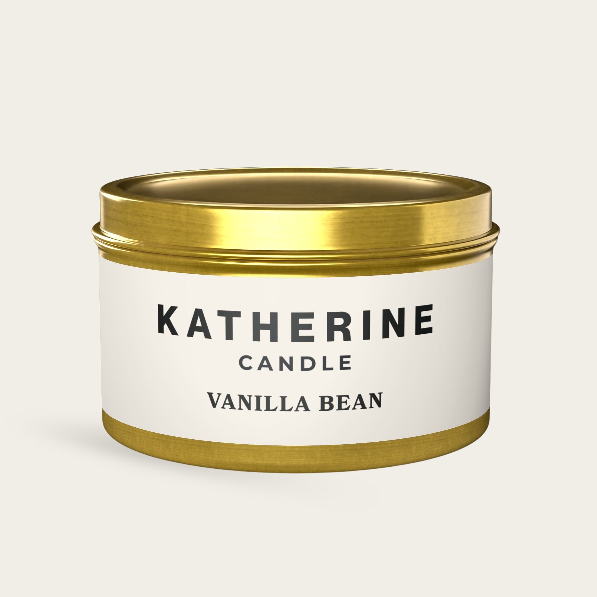 Gold candle jar with banded lid and base; white label shows vanilla bean