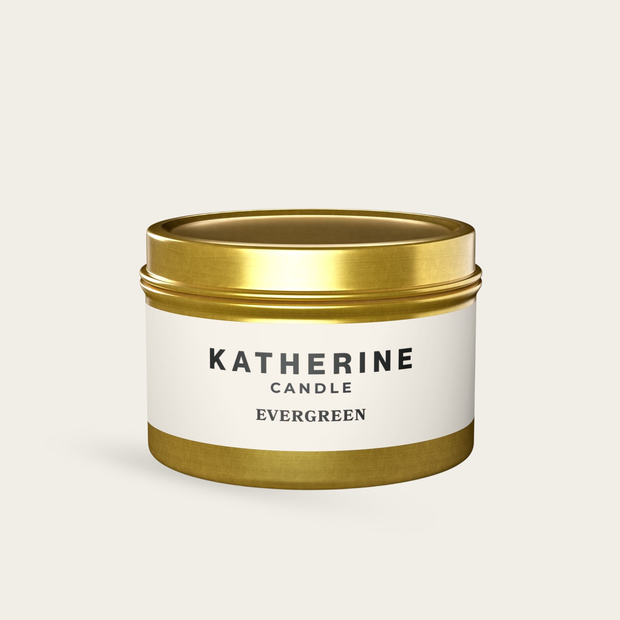 Scented candle jar with gold lid and gold band, white label reading Evergreen
