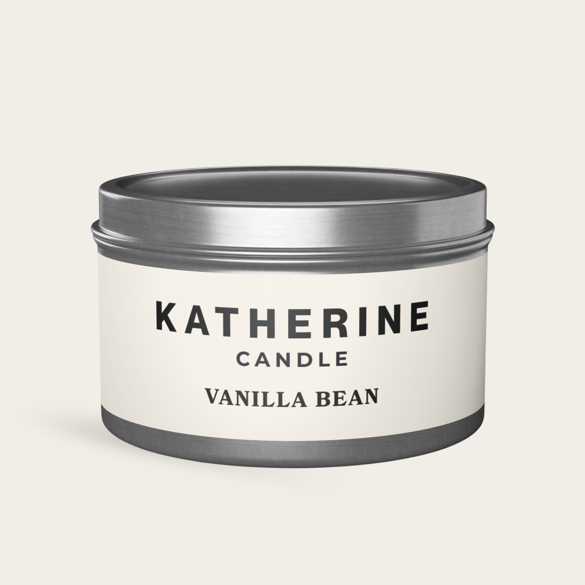 Silver candle jar with banded lid and base; white label shows vanilla bean