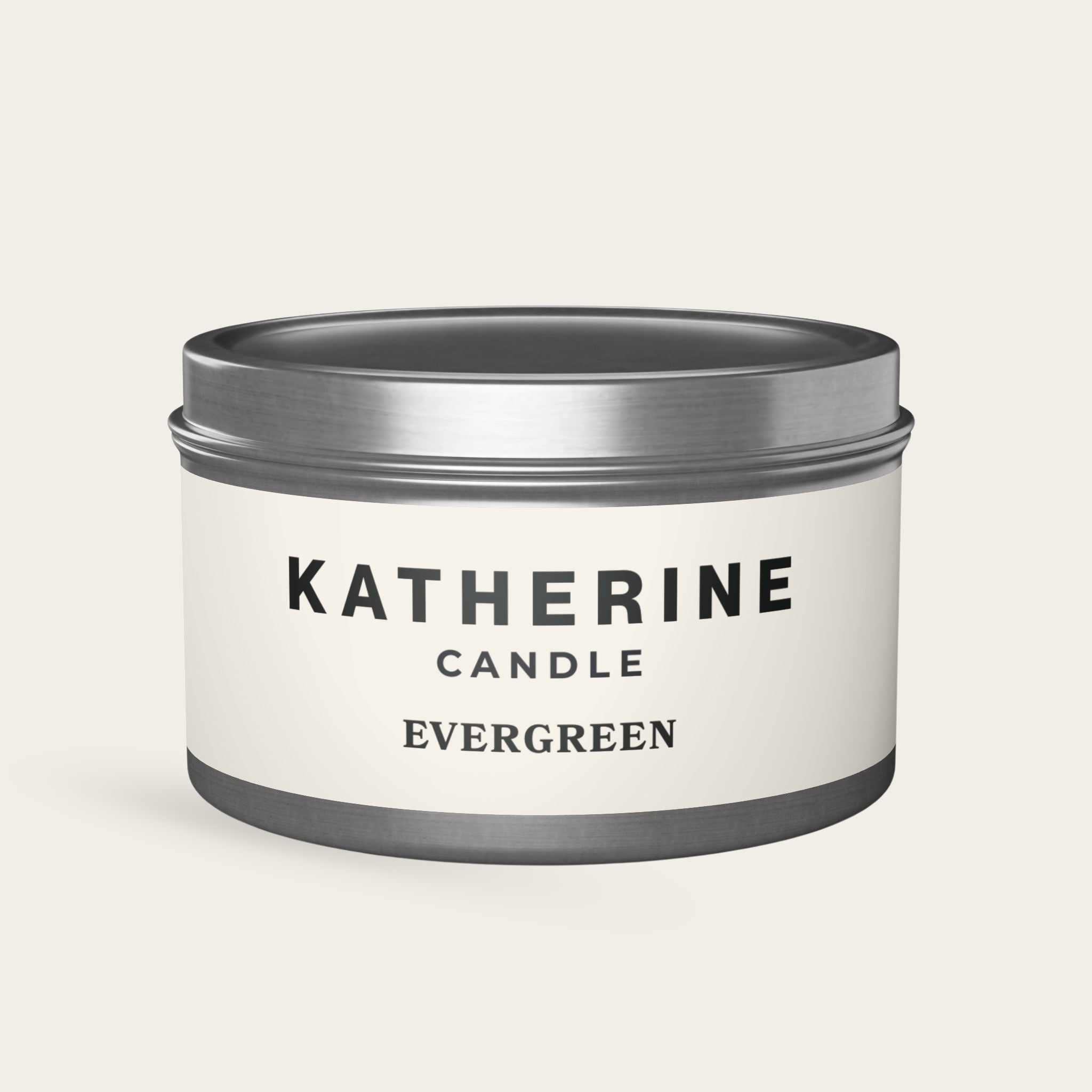 Scented candle jar with silver lid and band, white label reading Evergreen